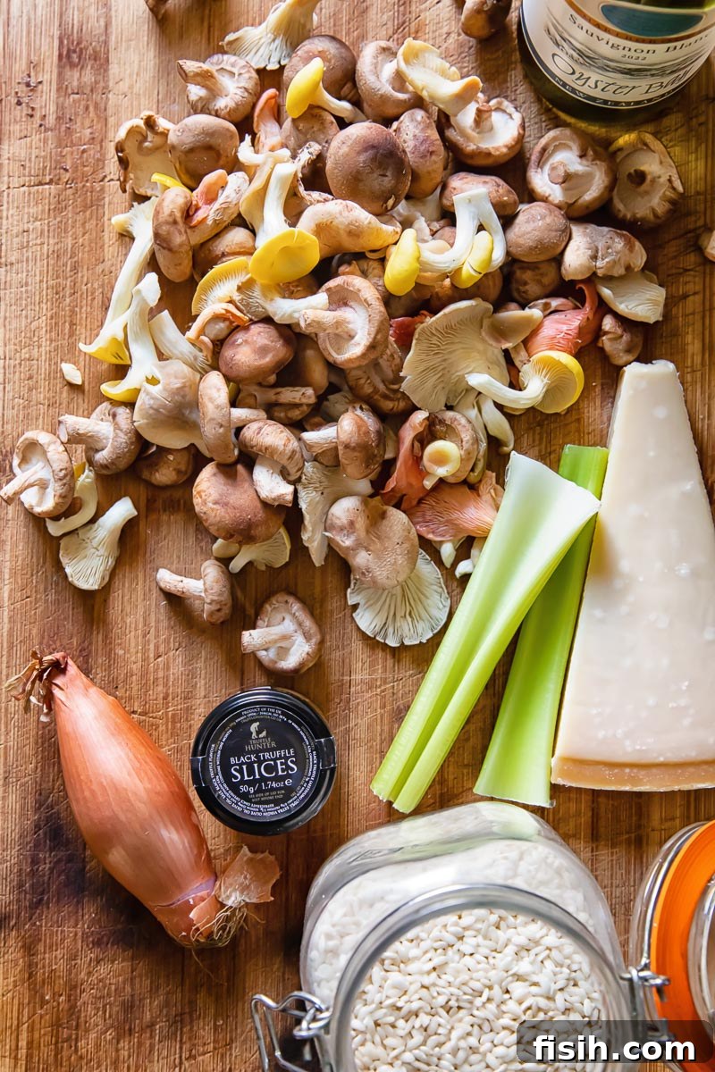 top dow view of wild mushrooms, a shallot, 2 celery sticks, a wedge of Parmesan and truffles in a small jar
