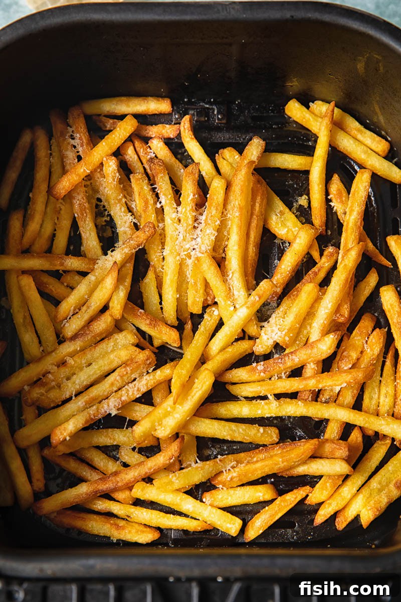 Process shot of parmesan truffle fries in air fryer tray