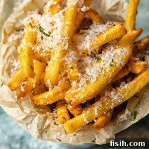 Top down view of truffle fries in a bowl sprinkled with parmesan