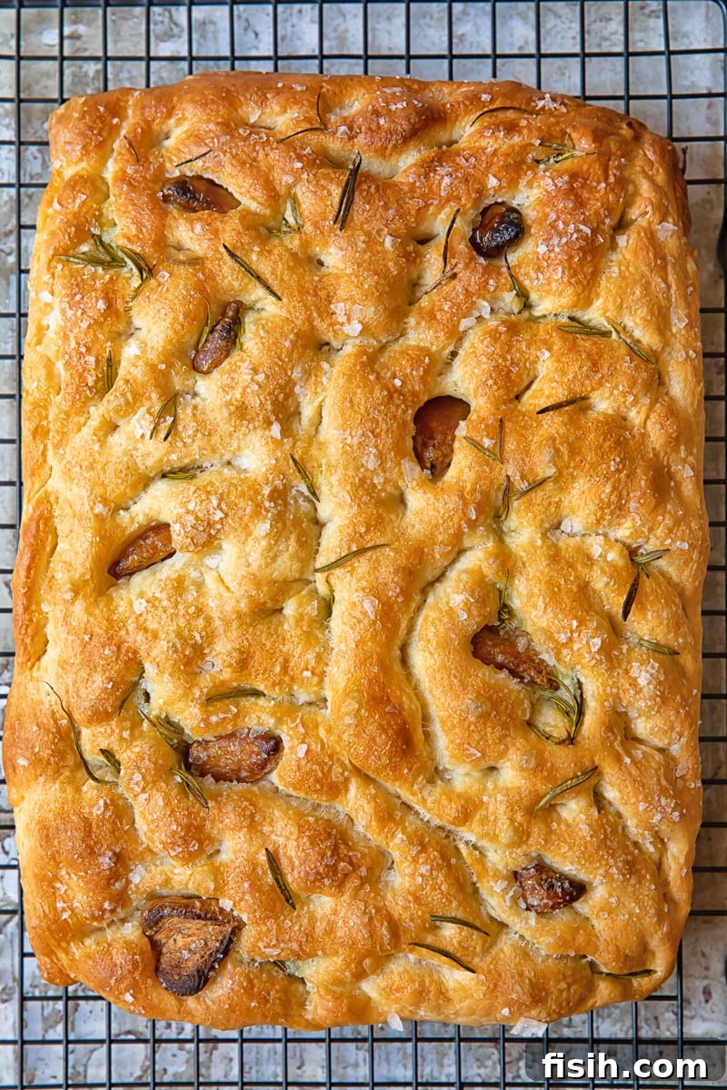 Effortless Artisan Focaccia 4 Golden focaccia bread cooling on a wire rack, showcasing its texture and golden crust.