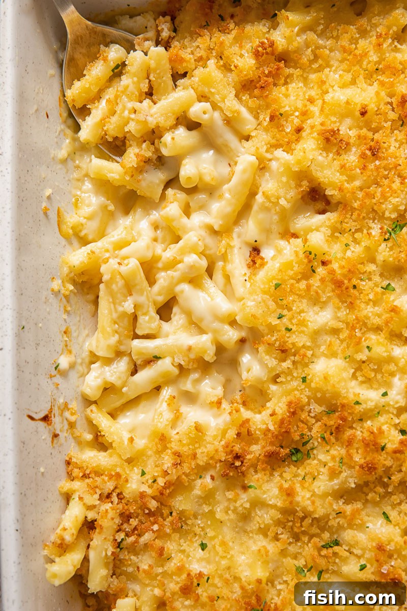 Gourmet Truffle Mac and Cheese 4 Close up view of truffle mac and cheese in a baking dish, showcasing its gooey texture.