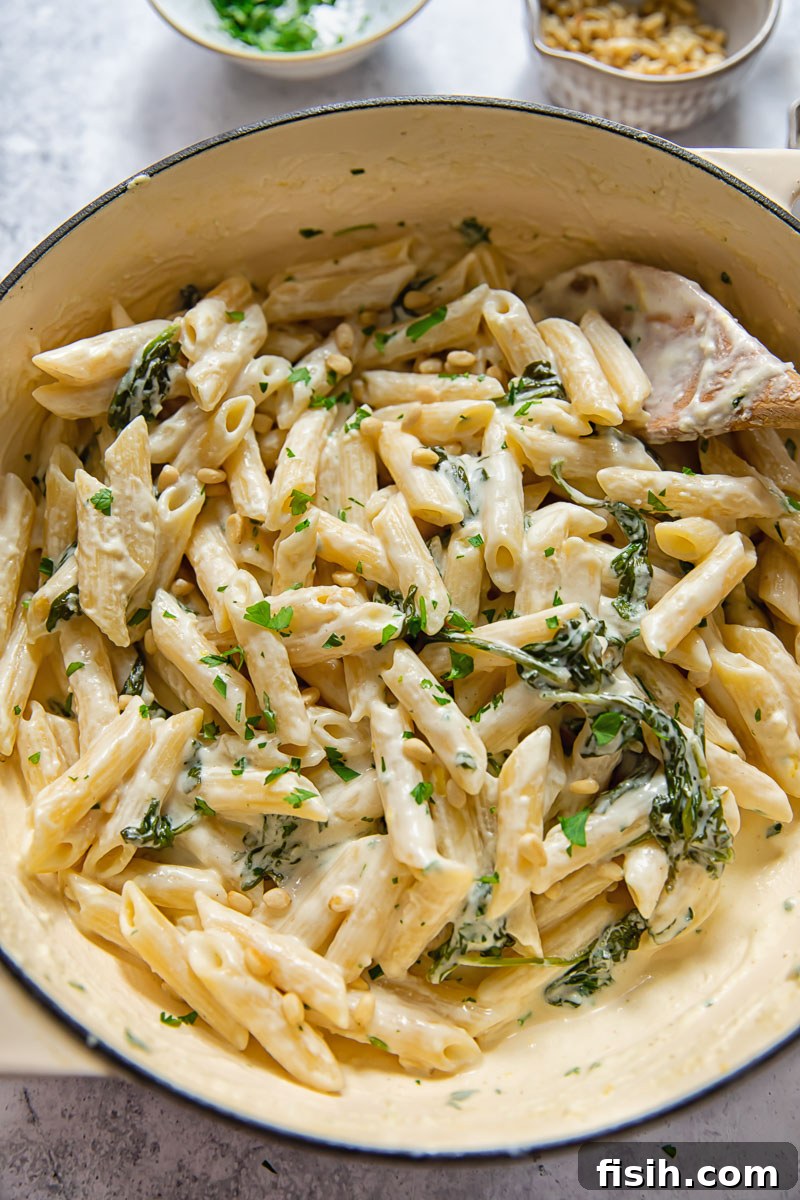 Overhead view of a pan filled with the finished creamy goat cheese pasta, ready to be dished out.