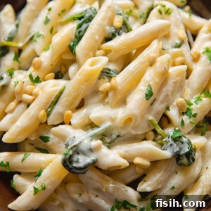 A beautiful plate of goat cheese pasta, adorned with fresh parsley and scattered pine nuts, ready for serving.