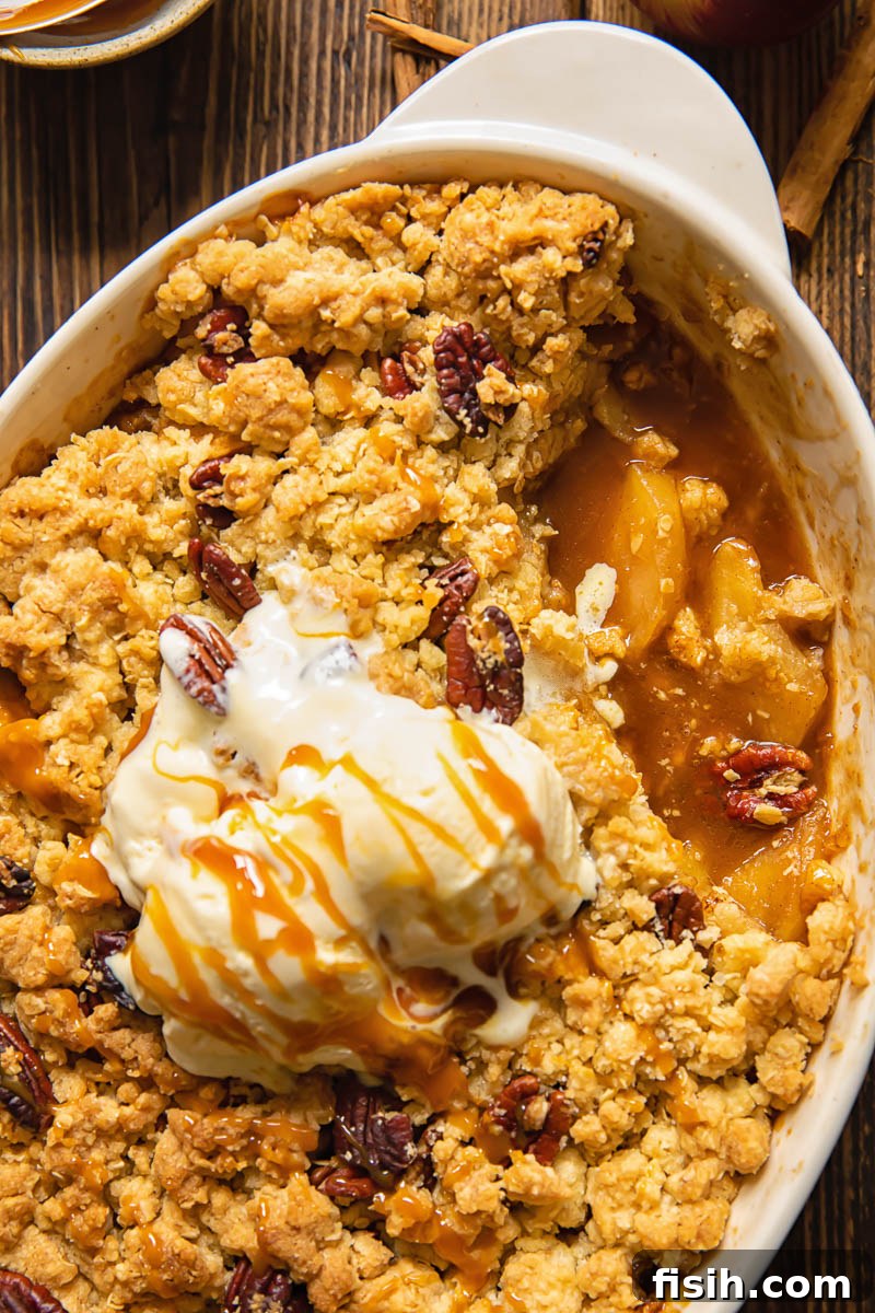 Effortless Apple Crisp from Scratch 5 Top down shot of a baked apple crisp in a baking dish with one serving removed, revealing the tender apple filling and golden topping.