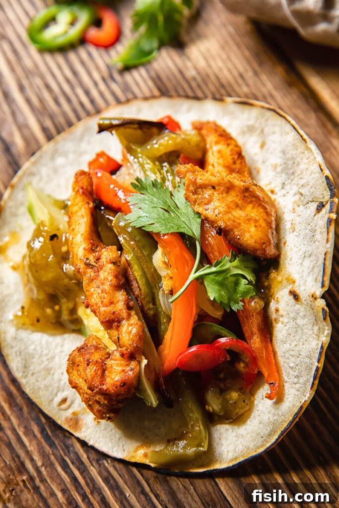Top down view of a chicken fajita with salsa and roasted peppers