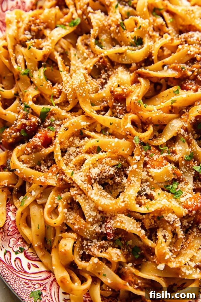 Close up of tagliatelle pasta mixed generously with rich mushroom bolognese sauce.