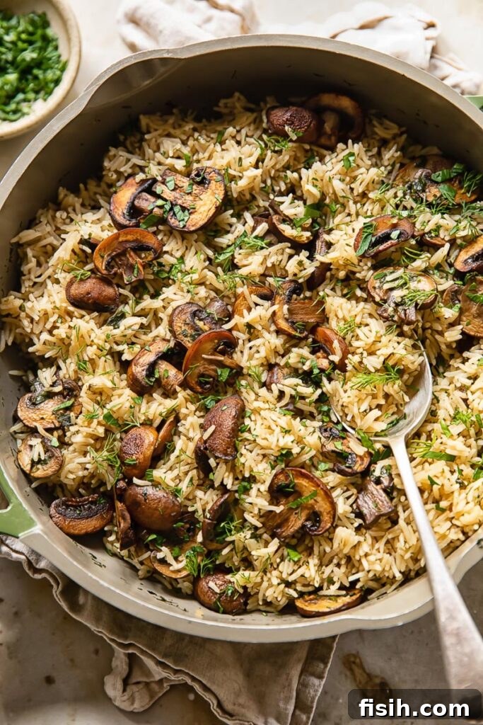 Earthy Mushroom Herb Pilaf 2 Top down view of herbed mushroom rice in a pot, garnished with fresh parsley, ready to be served as a flavorful side dish.
