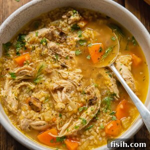 Top down view of chicken and mushroom soup in a bowl with bulgur and fresh dill