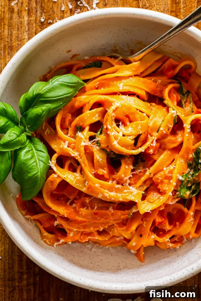 Close up shot of fresh tagliatelle pasta tossed in the creamy tomato and mascarpone sauce, ready to be served.