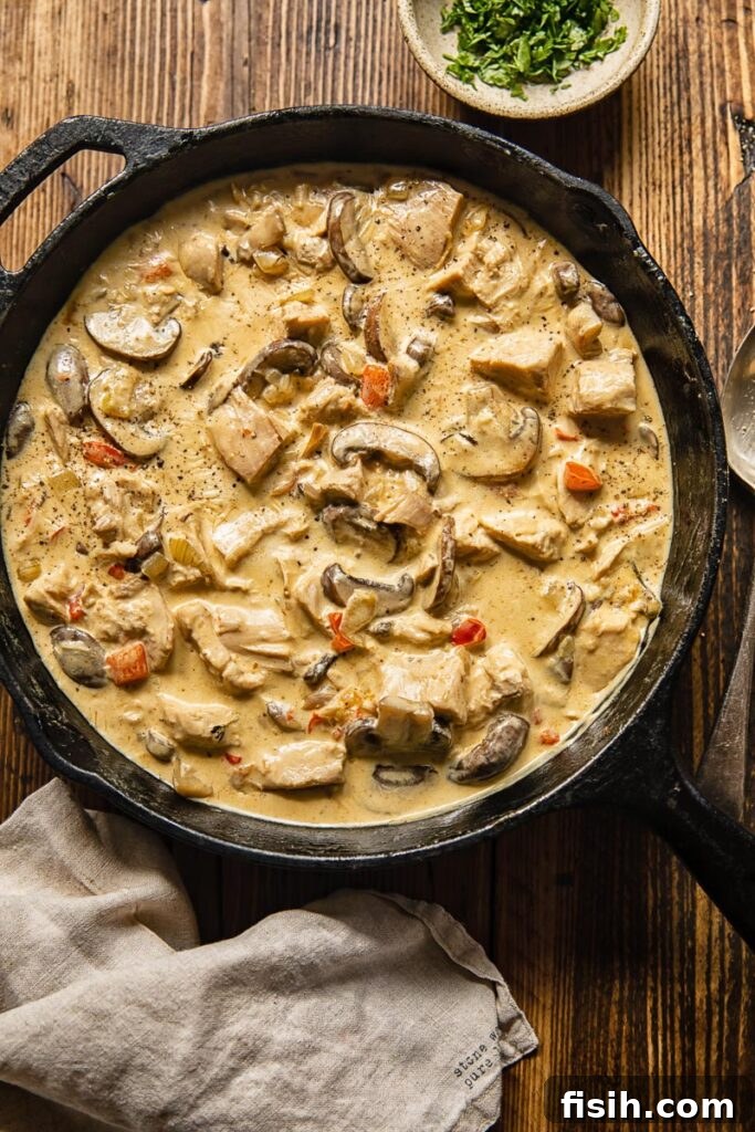 Top down view of Turkey a la King in a pan with peppers and mushrooms