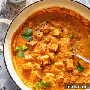 large pan of paneer tikka masala beside bowl of cilantro