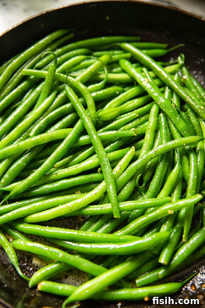 Bright Lemon Butter Green Beans 3 Close up shot of vivid green beans coated in a glossy lemon butter sauce.