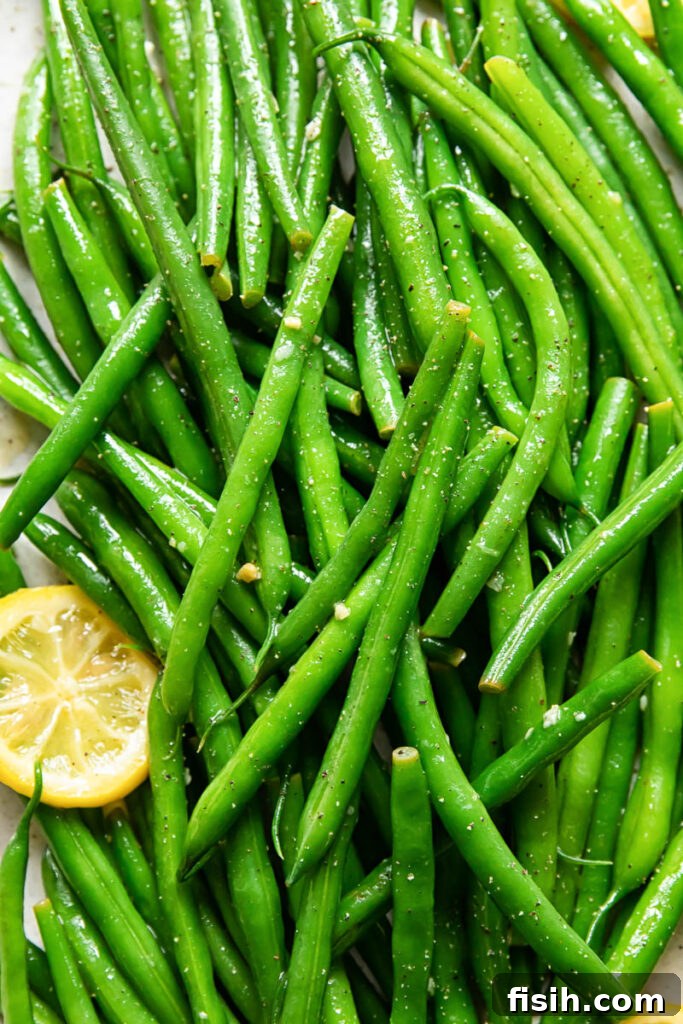 Bright Lemon Butter Green Beans 5 Platter of lemon butter green beans, elegantly arranged with fresh lemon wedges.