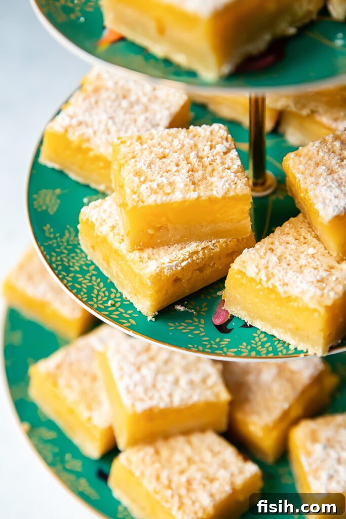 Zesty Lemon Delights 4 Side shot of many lemon bar pieces dusted with powder sugar on a platter