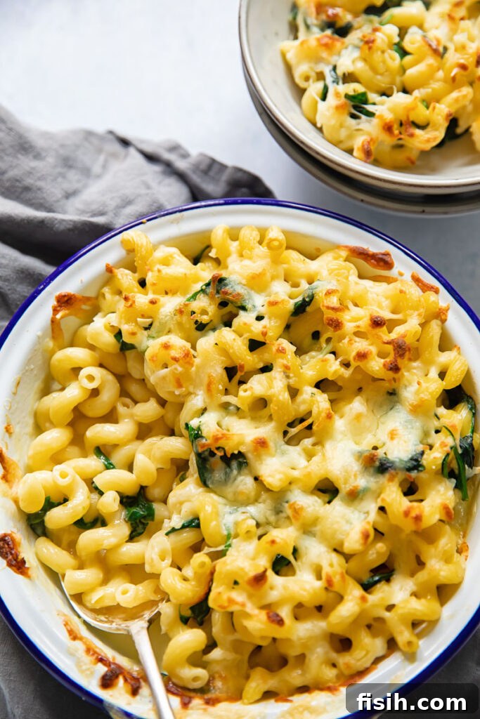 Top down view of brie mac and cheese in a baking dish, with golden crust and gooey cheese inside.