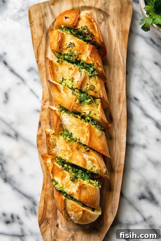 Top down shot of cheesy air fryer garlic bread on a cutting board, generously sprinkled with fresh parsley and ready to serve.
