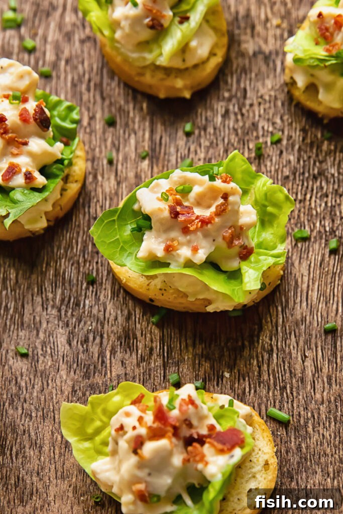 Crispy Caesar Chicken Bites 2 Close-up of elegant Chicken Caesar Crostini, featuring creamy chicken salad, crisp lettuce, and bacon bits on a golden crostini base, ready for a party.