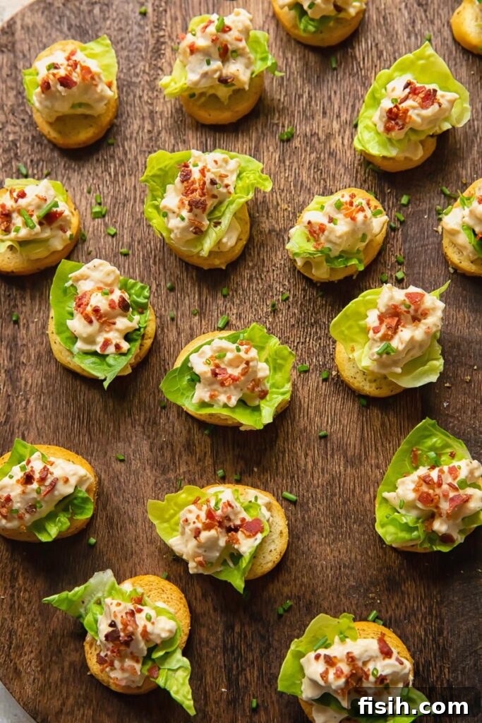 Crispy Caesar Chicken Bites 3 Top-down view of multiple Chicken Caesar Crostini arranged neatly, showcasing their vibrant colors and crispy bacon toppings.