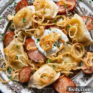 Bowl of pierogies and sliced kielbasa topped with crispy caramelised onions