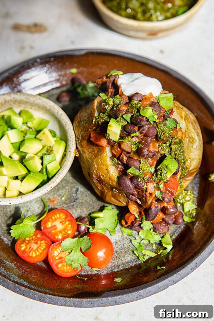 Plate with jacket potato with added toppings and avocado