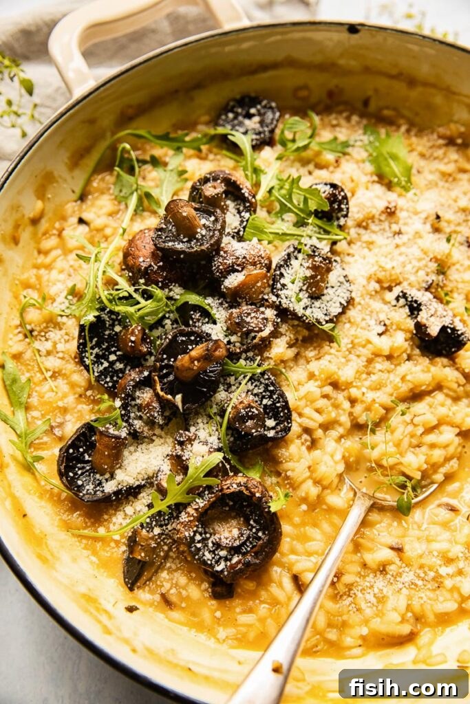 Earthy Roasted Mushroom Risotto 5 Close-up of a serving of roasted mushroom risotto, garnished with fresh herbs and grated cheese.