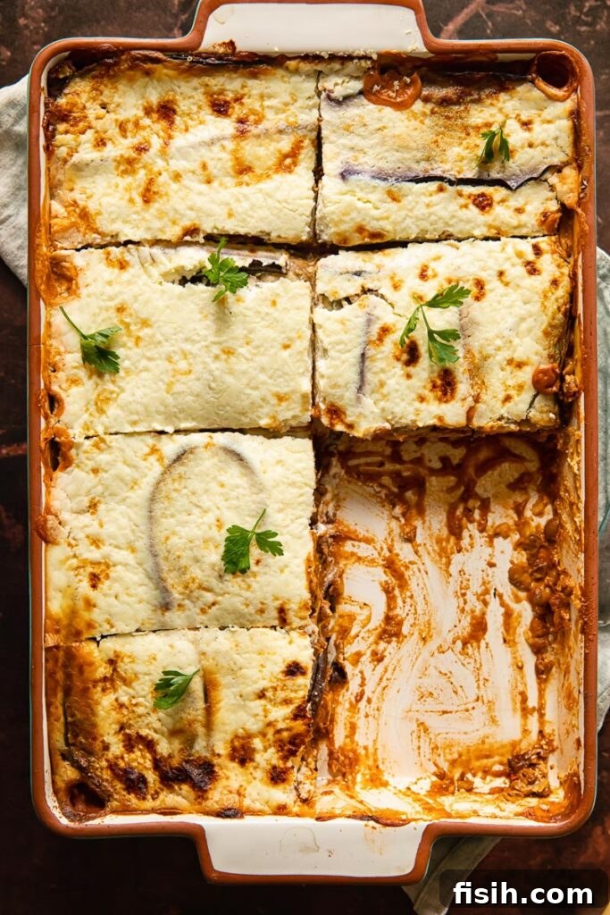 Wholesome Plant-Based Lentil Moussaka 2 Vegetarian moussaka in a baking dish with pieces removed