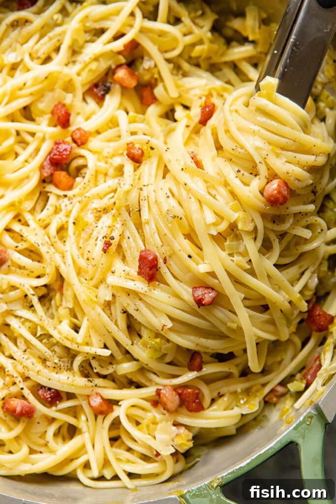 Close-up of the creamy leek and pancetta pasta served in a rustic pan, ready to be enjoyed.
