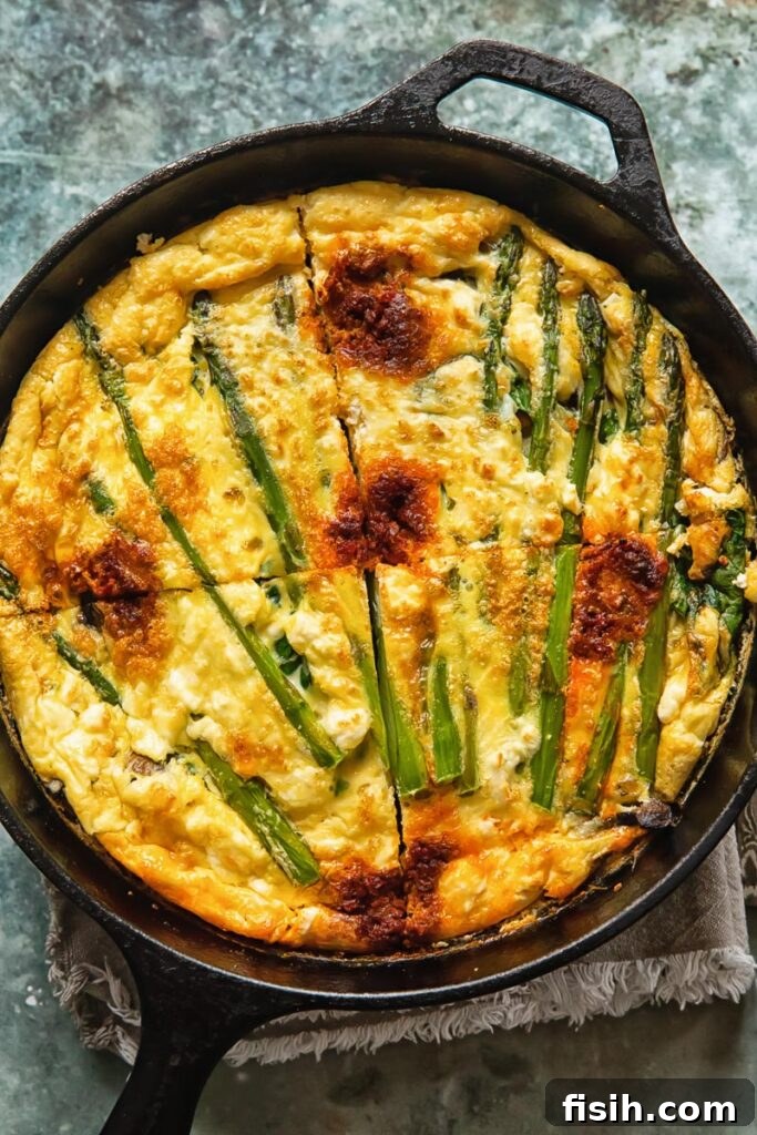 Vegetable frittata in a cast iron pan cut into quarters, ready to serve
