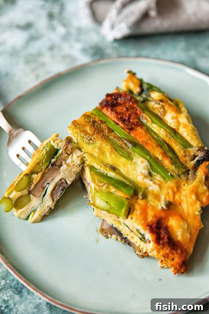 A beautiful slice of vegetable frittata on a white plate, showcasing its layers