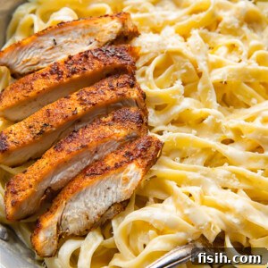 Bold Blackened Chicken Alfredo 6 Top down shot of tagliatelle in alfredo sauce topped with blacken chicken strips in a bowl
