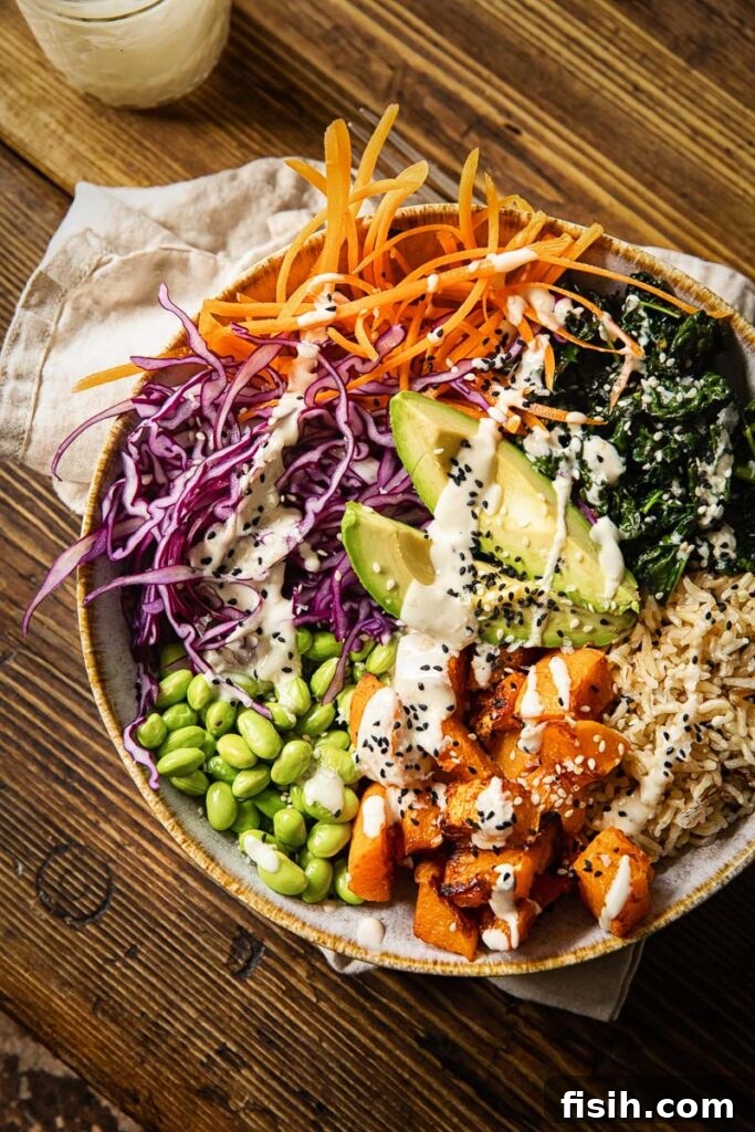 A beautifully plated Buddha bowl, viewed from above, showcasing a rich array of colorful and nutritious ingredients, artfully arranged on a wooden surface.