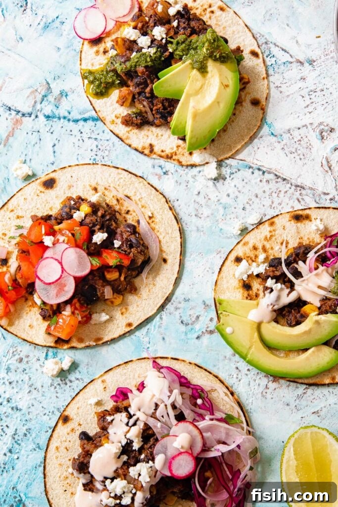 Black Bean Corn Tacos Topped with Zesty Cilantro Lime Slaw 3 Four black bean and corn tacos lying open with range of toppings