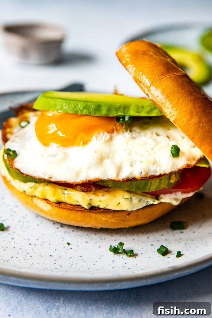 Bagel sandwich with the top askew on a plate