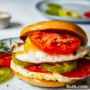 Bagel sandwich with the top angled off and a tomato on top