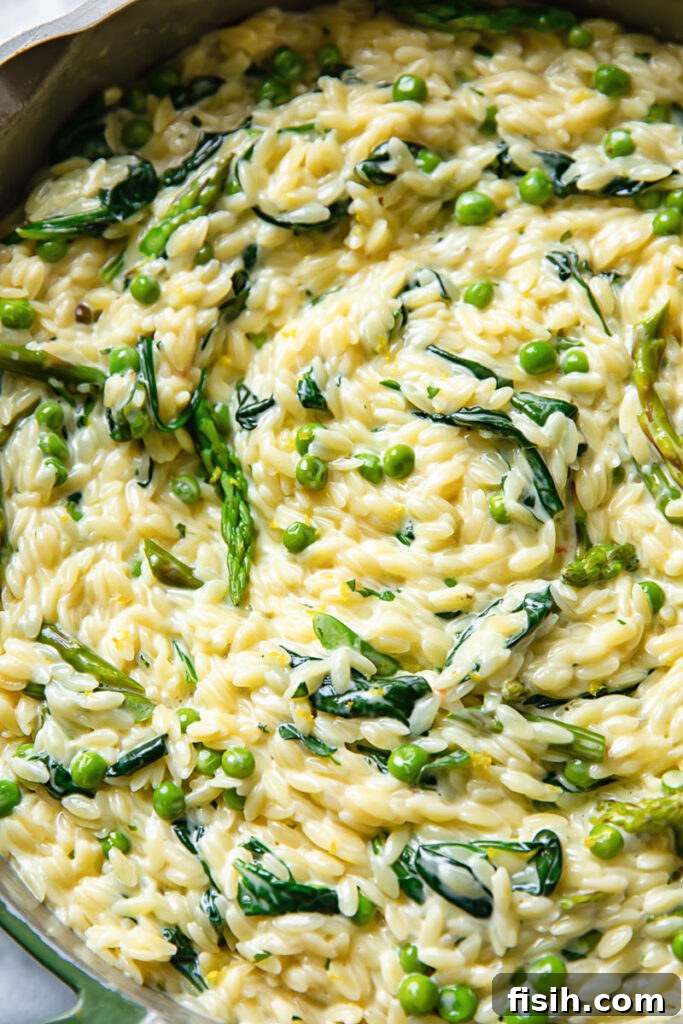 Close up shot of pasta primavera in a pot with spring vegetables and herbs