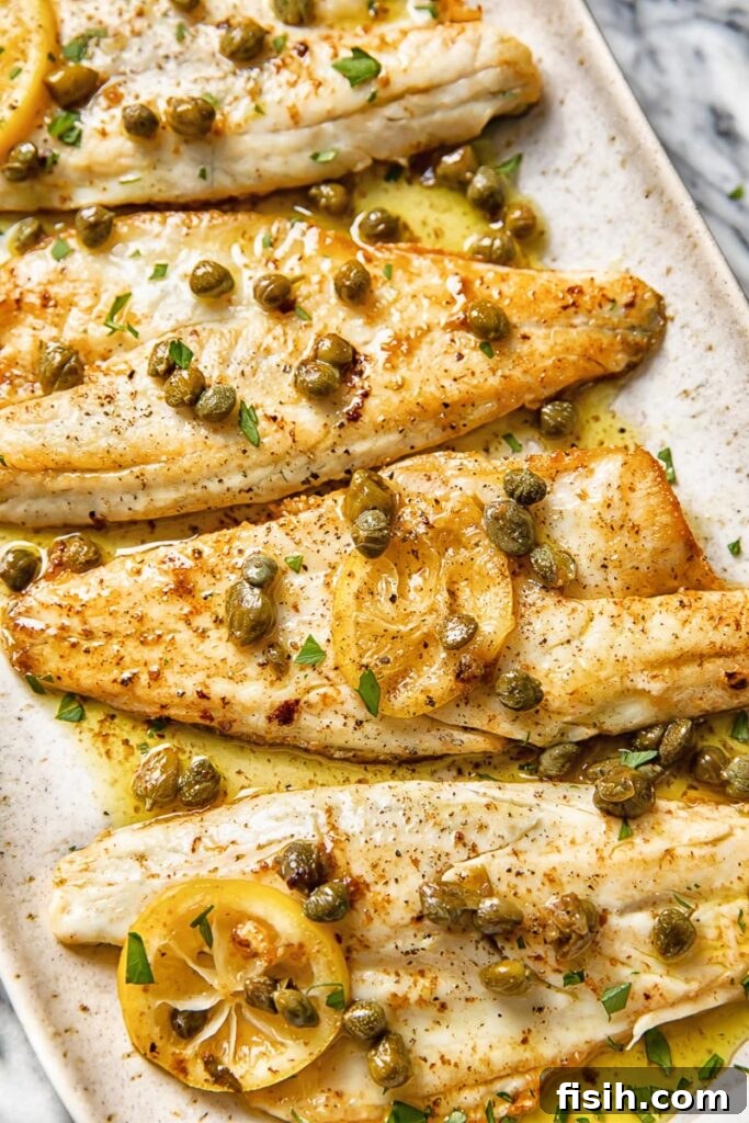 Pan-Seared Sea Bass with Nutty Caper Butter 3 close up of sea bass fillets in brown butter caper sauce garnished with fresh parsley