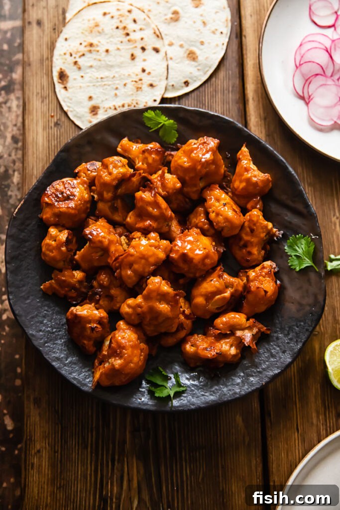 Air Fryer Buffalo Cauliflower Bites on a plate, garnished with fresh herbs