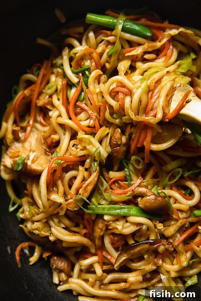 Vegetarian Yaki Udon Stir-Fry 3 Close up view of the vegetarian yaki udon being tossed and stirred in a pan, highlighting the glossy noodles and colorful vegetable medley.