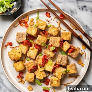 Plate of air fryer tofu bites with cop sticks and side dish of green onions