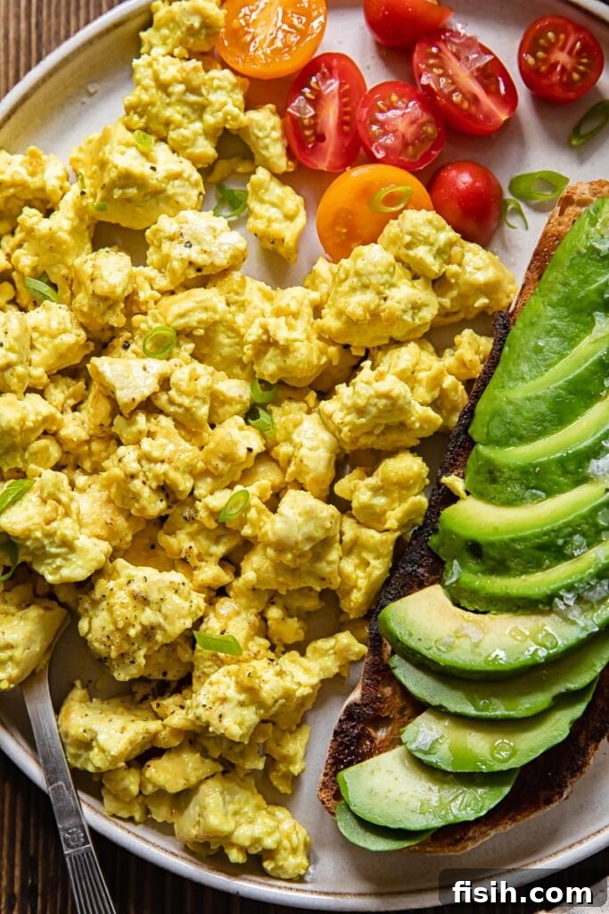 Plate of egg tofu scramble with avocado and tomatoes