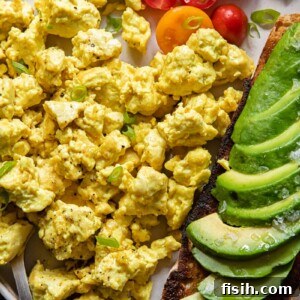 Plate of egg tofu scramble with avocado and tomatoes