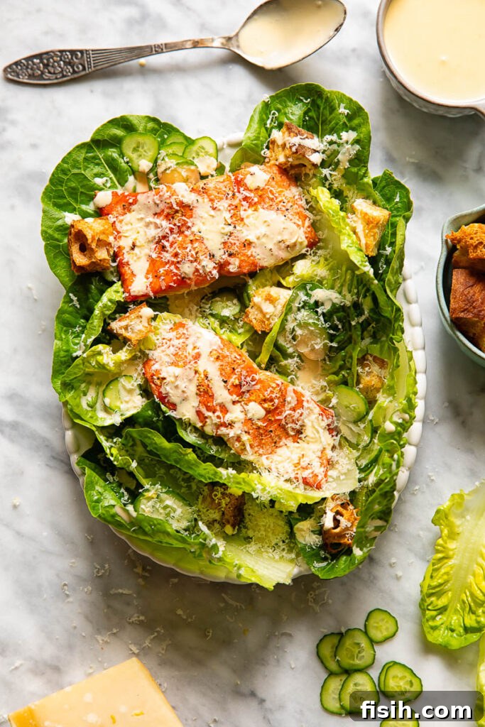 Elevated Salmon Caesar 3 Top down shot of salmon Caesar salad on a small platter next to a bowl of croutons