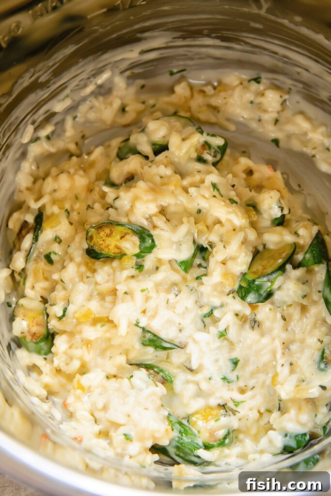 Creamy Instant Pot Zucchini Risotto with Garlic-Herb Boursin 3 Top down shot of zucchina and parsley being mixed into risotto in an instant pot