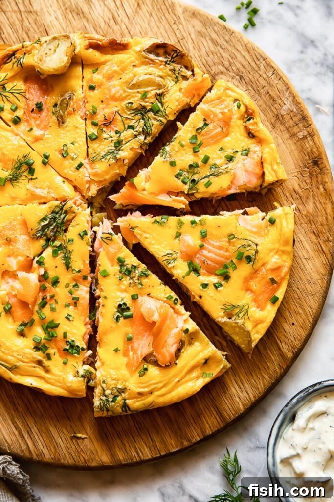 Savory Smoked Salmon and Dill Frittata 4 Top down shot of smoked salmon frittata on a cutting board cut into slices and topped with fresh chives