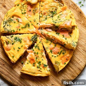 Top down shot of salmon frittata slices on a platter topped with herbs