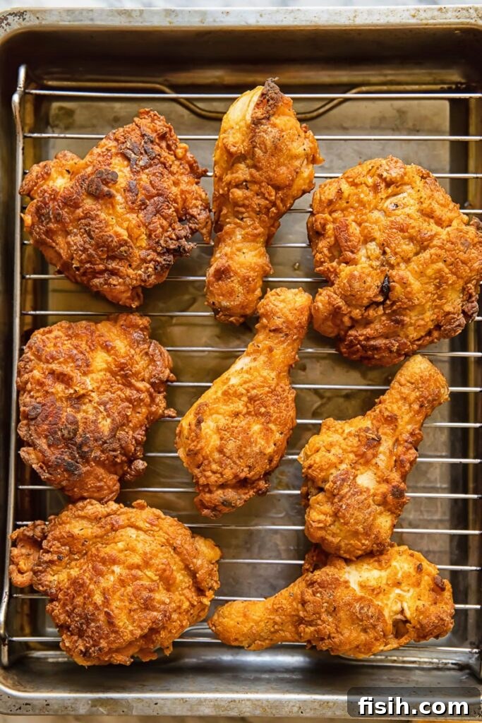 Top down shot of buttermilk fried chicken pieces cooling on a wire rack