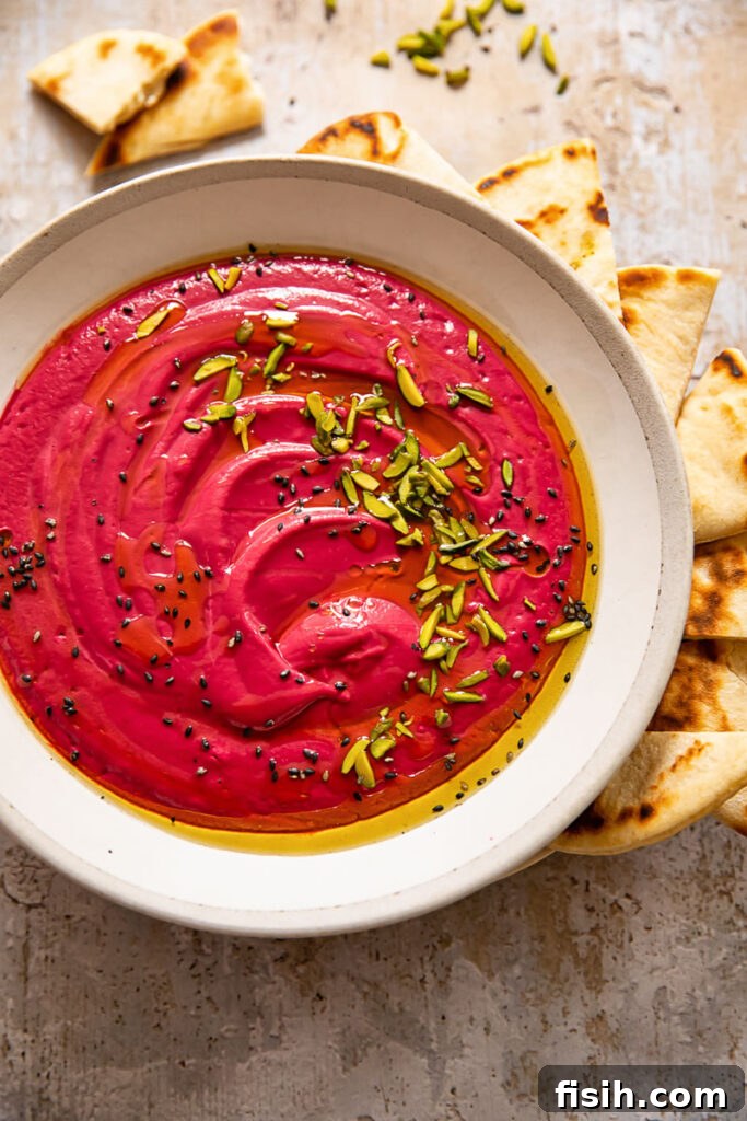 Bowl of beetroot borani with seeds, mint and flatbread, showcasing its rich purple color and inviting texture.