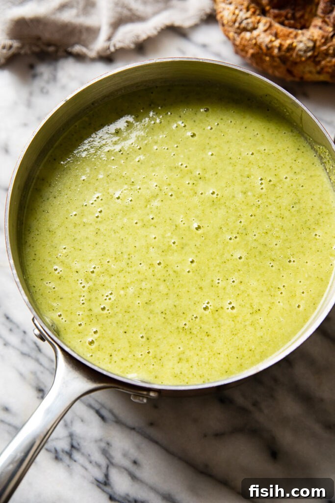 A small pot of steaming, hearty broccoli and cauliflower soup, perfectly blended to a creamy consistency.