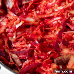 Close up shot of braised cabbage and beets in a large pot with bacon bits