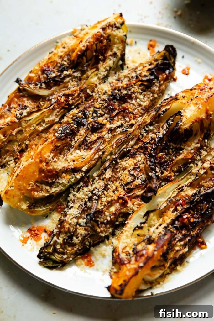 Close up shot of roasted cabbage on a plate, quartered and topped with breadcrumbs